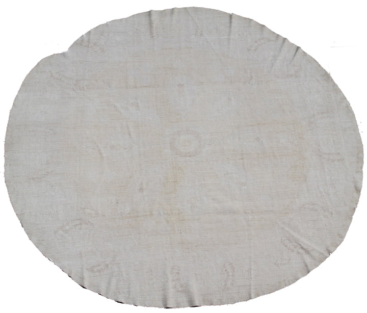 A round, beige rug with a pale washed-out floral design from the Ariana Vintage Collection.