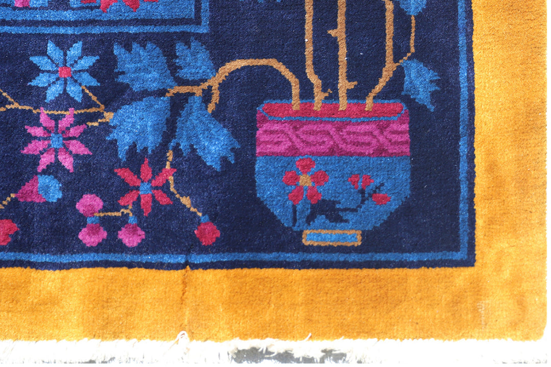 Close-up of a colorful rug with floral patterns and a vase design.