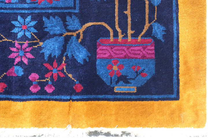 Close-up of a colorful rug with floral patterns and a vase design.