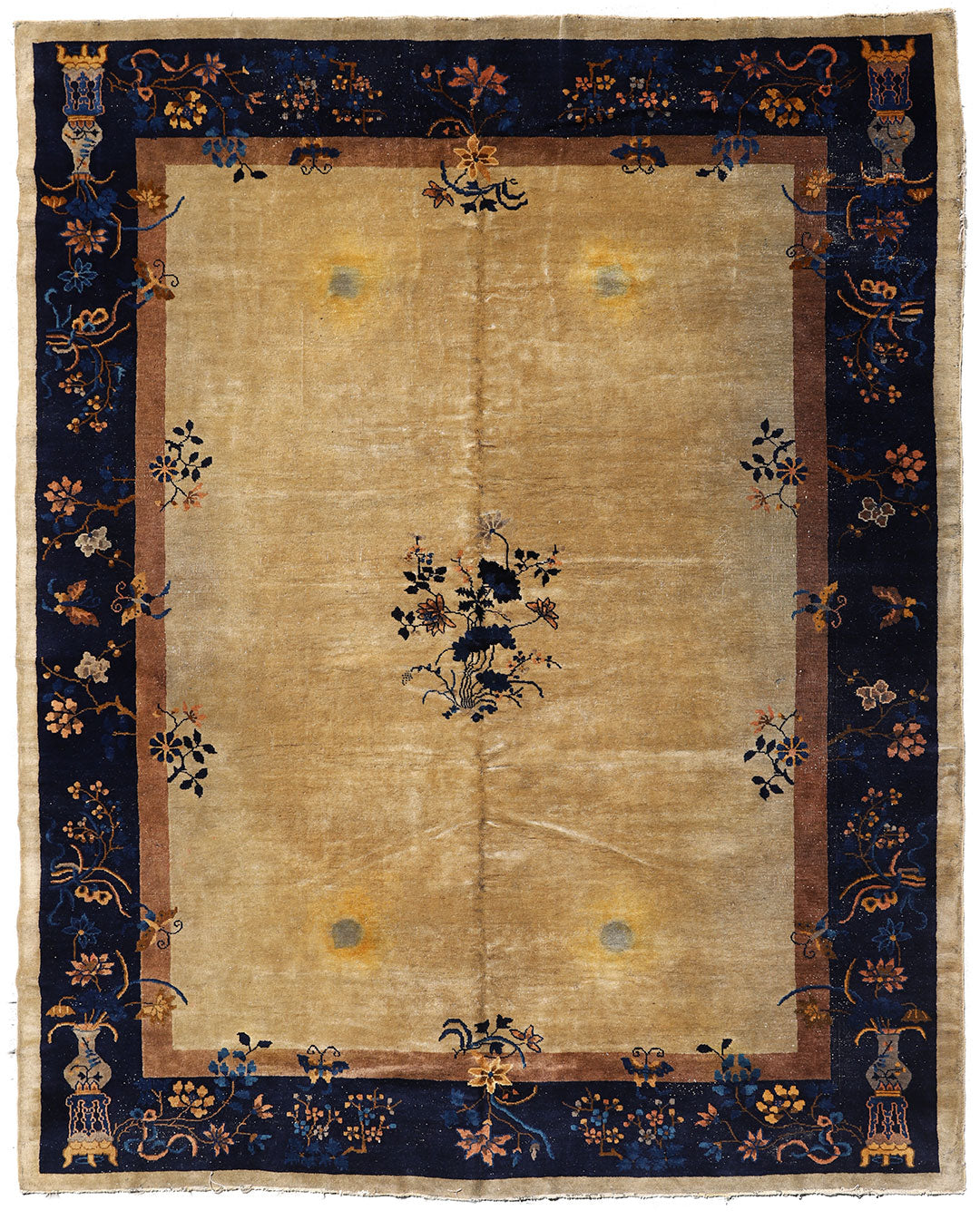 A beige and blue Art Deco style rug with floral and geometric patterns, showing signs of wear and stains.