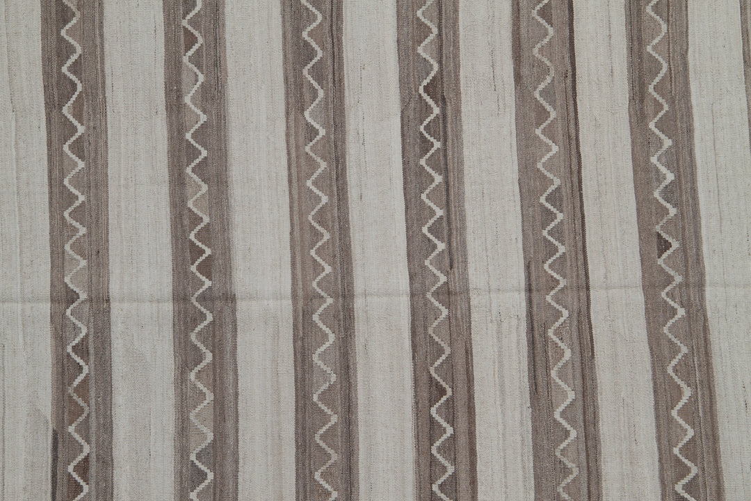 Handwoven beige and brown striped wool kilim with zigzag motif, crafted in Afghanistan. Luxury flatweave rug from the Ariana Kilim Collection.
