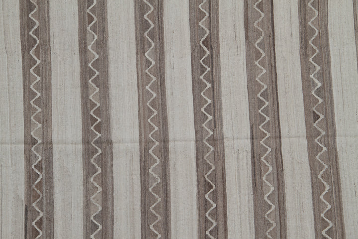 Handwoven beige and brown striped wool kilim with zigzag motif, crafted in Afghanistan. Luxury flatweave rug from the Ariana Kilim Collection.