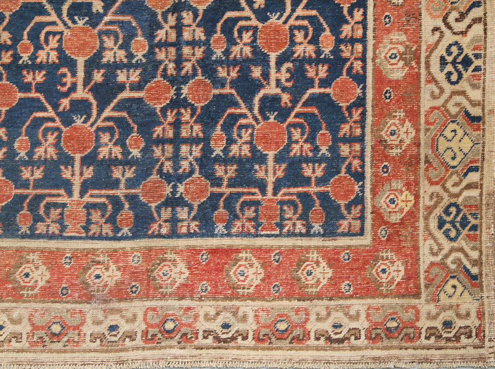 Rare 6x11 antique Samarkand hand-knotted wool area rug featuring red pomegranate motifs on a deep navy blue background by Ariana Rugs.