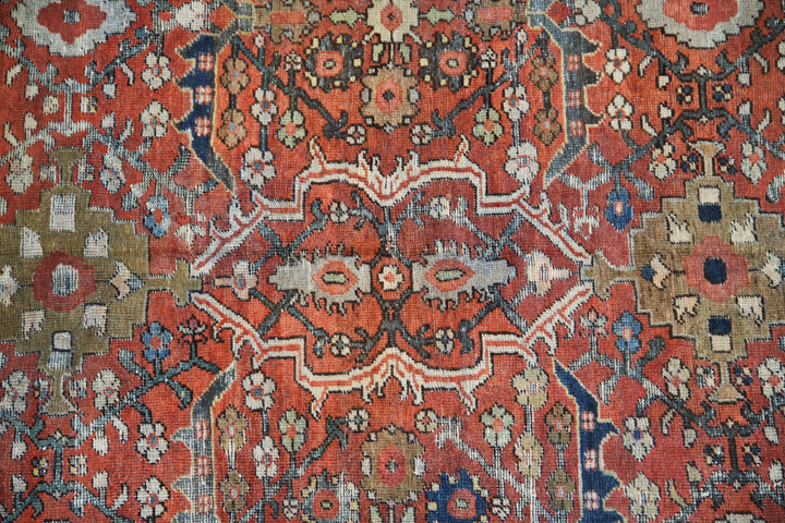 9x12 antique Persian Mahal rug with terracotta rust ground, navy blue geometric border, and ivory details