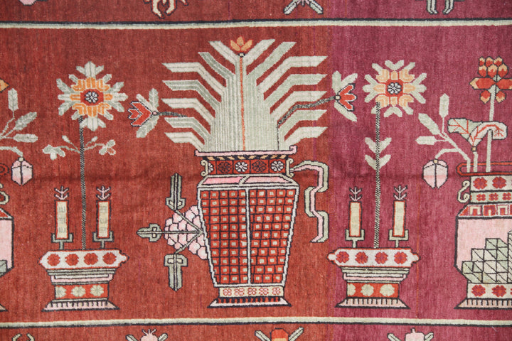 Rare 5x9 antique Yarkand Samarkand hand-knotted wool rug featuring a vase design on a reddish-purple abrash field by Ariana Rugs.