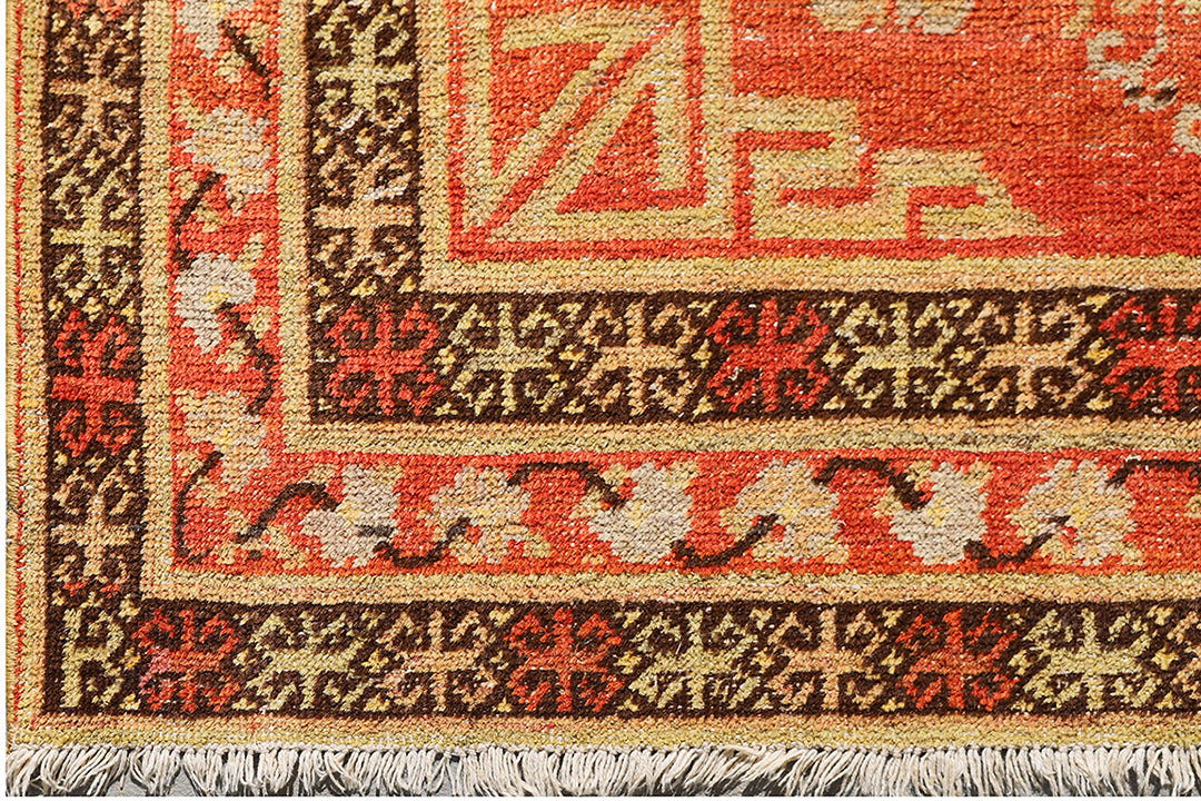Authentic antique hand-knotted Samarkand Khotan wool area rug featuring bold black and grey geometric medallions on a vibrant orange field