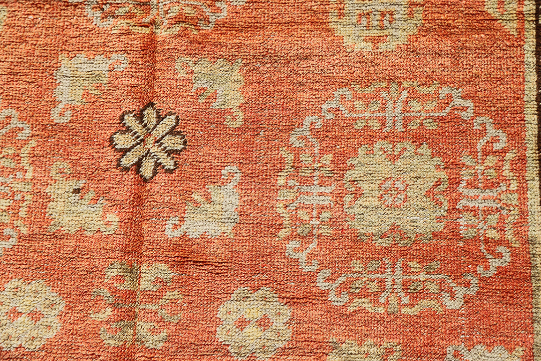 Authentic antique hand-knotted Samarkand Khotan wool area rug featuring bold black and grey geometric medallions on a vibrant orange field