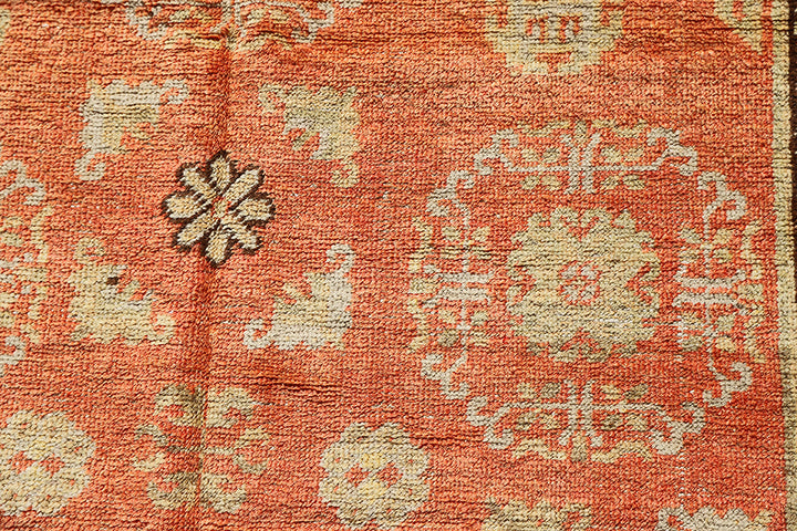 Authentic antique hand-knotted Samarkand Khotan wool area rug featuring bold black and grey geometric medallions on a vibrant orange field