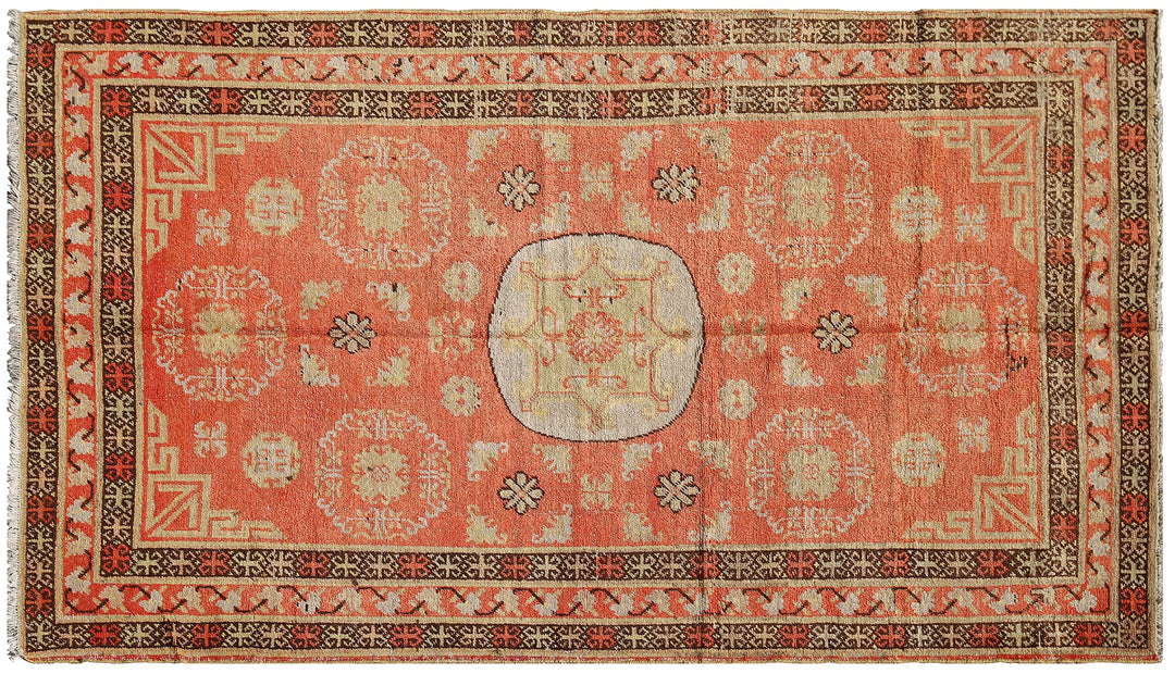 Authentic antique hand-knotted Samarkand Khotan wool area rug featuring bold black and grey geometric medallions on a vibrant orange field