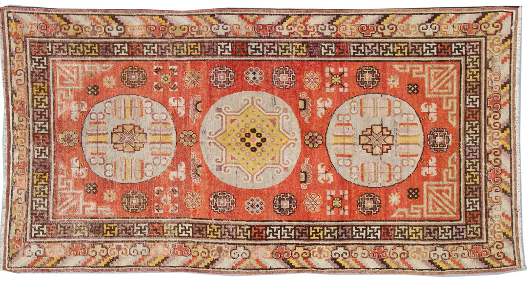 Authentic antique hand-knotted Samarkand Khotan wool area rug featuring three classic medallions in aqua and neutral tones on a rich orange-red field