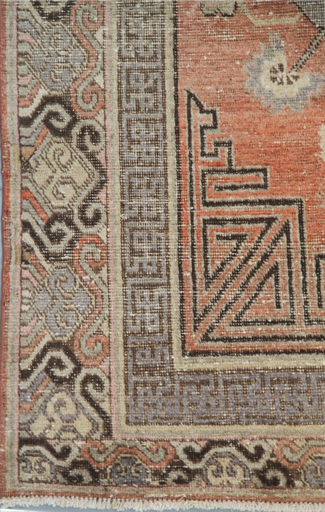 Authentic antique hand-knotted Samarkand Khotan wool area rug featuring classic medallions on a rich orange-red field with brown and cream accents