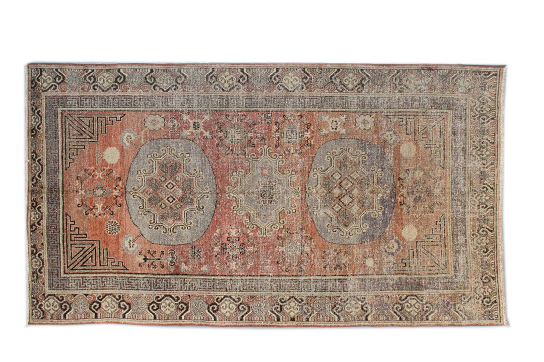 Authentic antique hand-knotted Samarkand Khotan wool area rug featuring classic medallions on a rich orange-red field with brown and cream accents