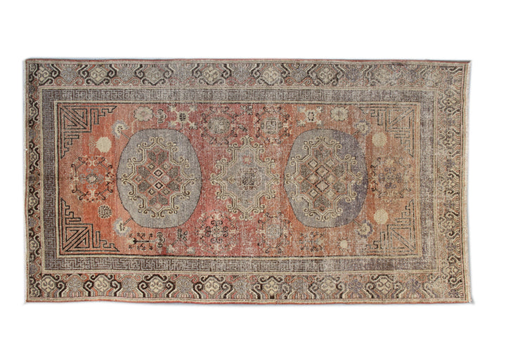 Authentic antique hand-knotted Samarkand Khotan wool area rug featuring classic medallions on a rich orange-red field with brown and cream accents