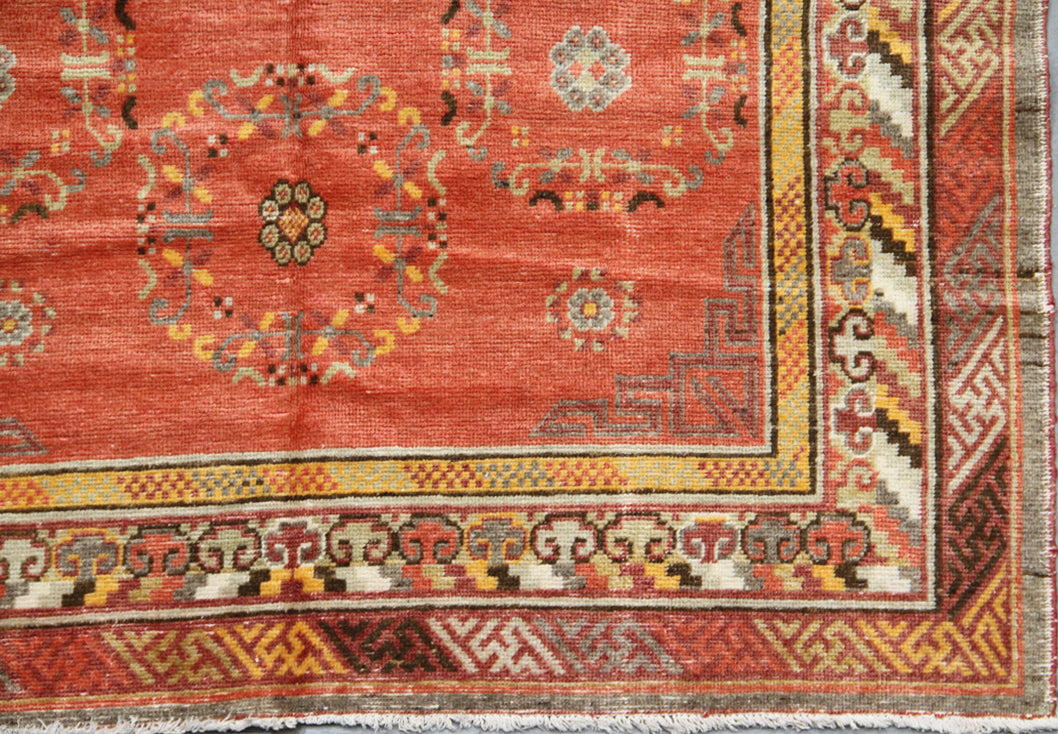 Authentic 2nd quarter 20th century hand-knotted Samarkand Khotan wool rug featuring an orange field with red pink beige botanical medallions