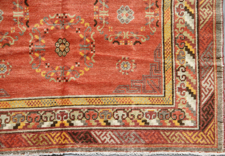 Authentic 2nd quarter 20th century hand-knotted Samarkand Khotan wool rug featuring an orange field with red pink beige botanical medallions