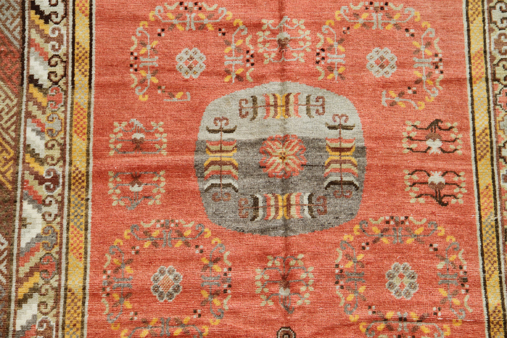 Authentic 2nd quarter 20th century hand-knotted Samarkand Khotan wool rug featuring an orange field with red pink beige botanical medallions