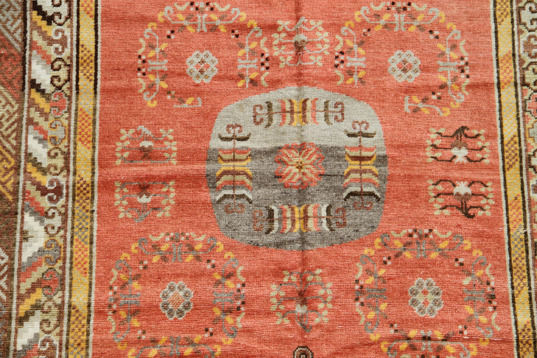 Authentic 2nd quarter 20th century hand-knotted Samarkand Khotan wool rug featuring an orange field with red pink beige botanical medallions