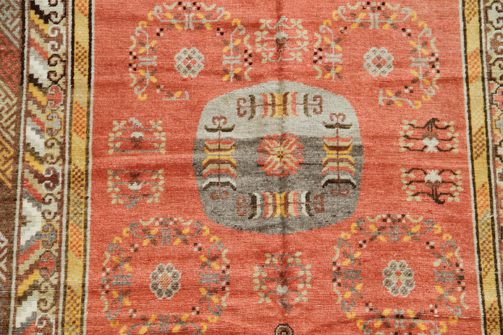 Authentic 2nd quarter 20th century hand-knotted Samarkand Khotan wool rug featuring an orange field with red pink beige botanical medallions