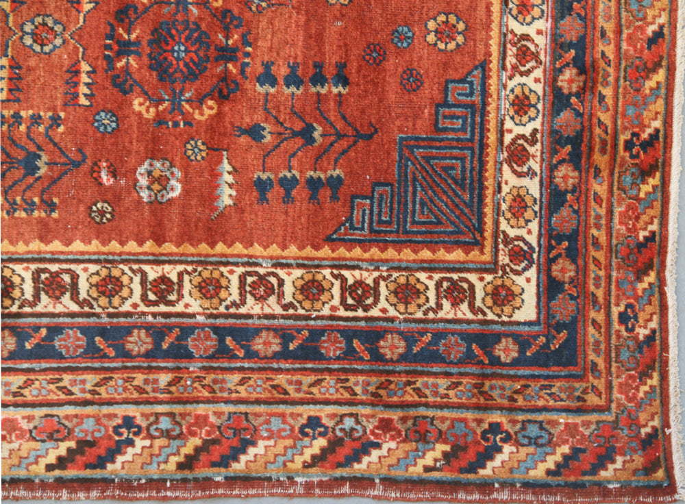Authentic antique hand-knotted Samarkand Khotan wool area rug featuring geometric medallions in blue, rust, and terracotta on a peach and ivory field