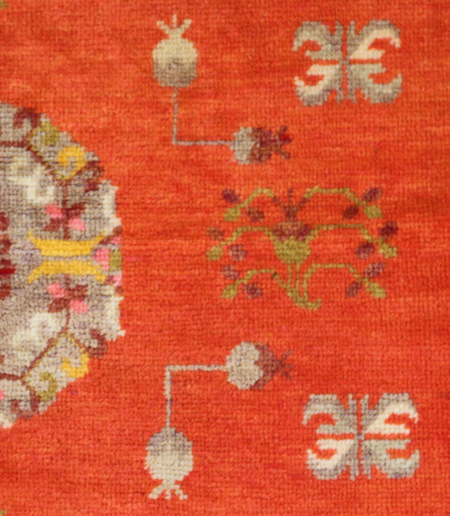 Authentic antique hand-knotted Samarkand Khotan wool area rug featuring a central medallion on a rich red field