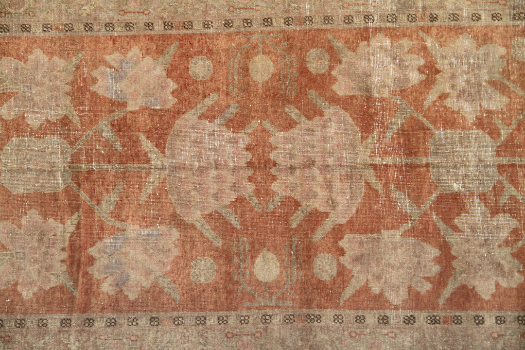 Authentic antique hand-knotted Samarkand Khotan wool area rug featuring salmon pink floral motifs on a warm rust field