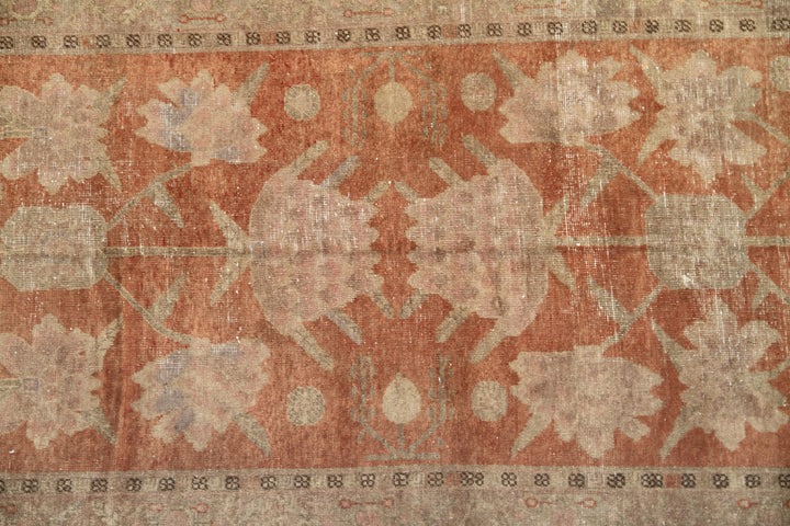 Authentic antique hand-knotted Samarkand Khotan wool area rug featuring salmon pink floral motifs on a warm rust field