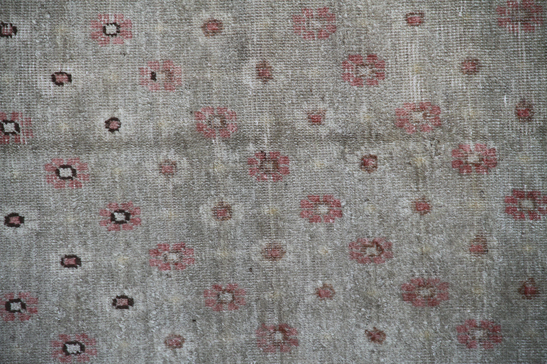 Rare 4x7 antique Samarkand hand-knotted wool rug featuring pink terracotta flowers on a soft green background by Ariana Rugs.
