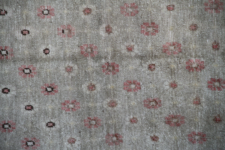 Rare 4x7 antique Samarkand hand-knotted wool rug featuring pink terracotta flowers on a soft green background by Ariana Rugs.