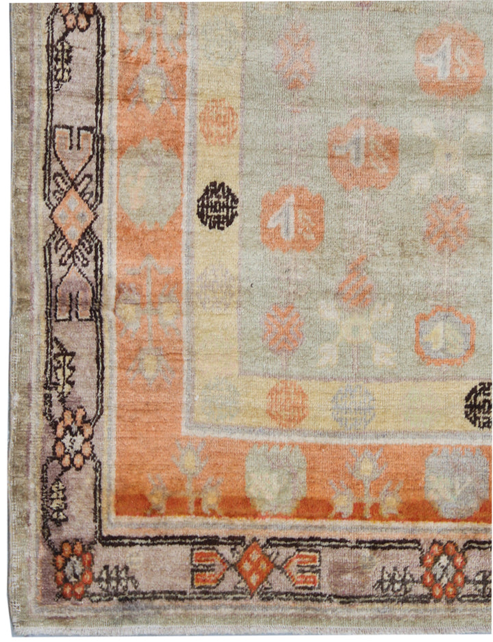 Rare 4x13 antique Samarkand hand-knotted wool gallery runner rug featuring orange medallions on a soft grey background by Ariana Rugs.