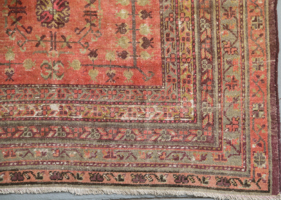 Authentic 5x8 antique Samarkand hand-knotted wool area rug featuring an all-over soft terracotta medallion design on a washed-out red field by Ariana Rugs.