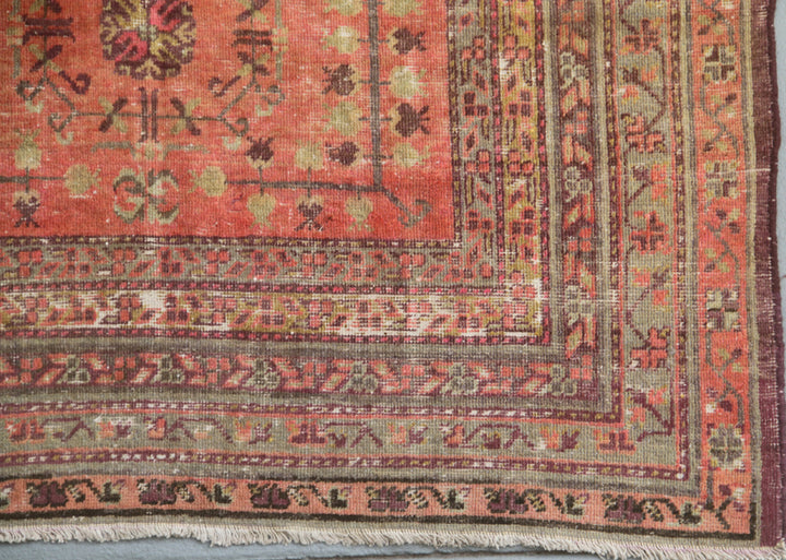 Authentic 5x8 antique Samarkand hand-knotted wool area rug featuring an all-over soft terracotta medallion design on a washed-out red field by Ariana Rugs.
