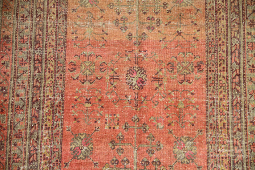 Authentic 5x8 antique Samarkand hand-knotted wool area rug featuring an all-over soft terracotta medallion design on a washed-out red field by Ariana Rugs.