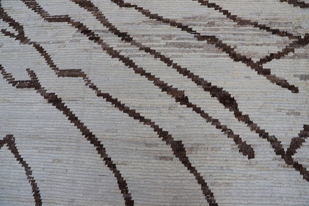 Hand-crafted 15'5" x 12'7" oversized Moroccan-style shag wool on cotton area rug featuring a brown and ivory zebra pattern from the Ariana Barchi Collection.
