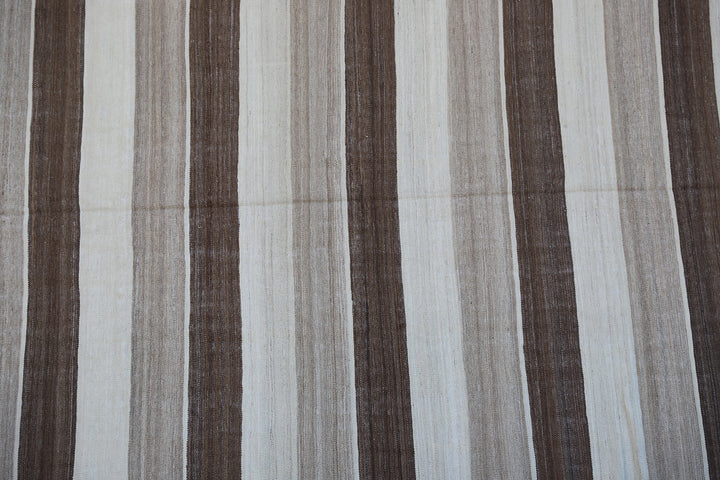 6x9 Ariana Kilim hand-woven Afghan wool rug with brown, beige, and cream stripes, full overhead view.
