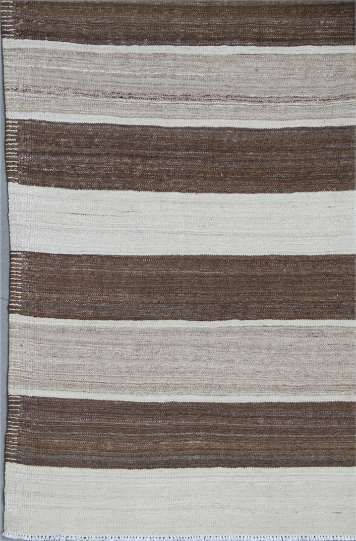Organic modern sitting room styled with a 6x10 earth-tone brown, tan, and cream striped Afghan wool kilim from Ariana Rugs West Hollywood.