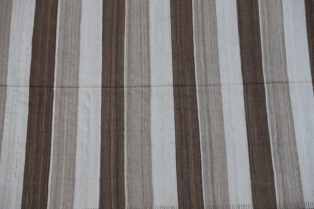 Close-up of organic hand-spun wool weave showing wide ivory and brown striped detail on Afghan kilim by Hazara weavers.