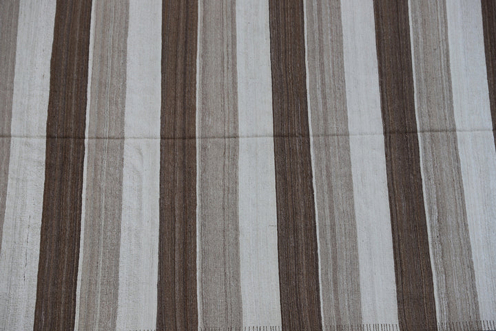 Close-up of organic hand-spun wool weave showing wide ivory and brown striped detail on Afghan kilim by Hazara weavers.