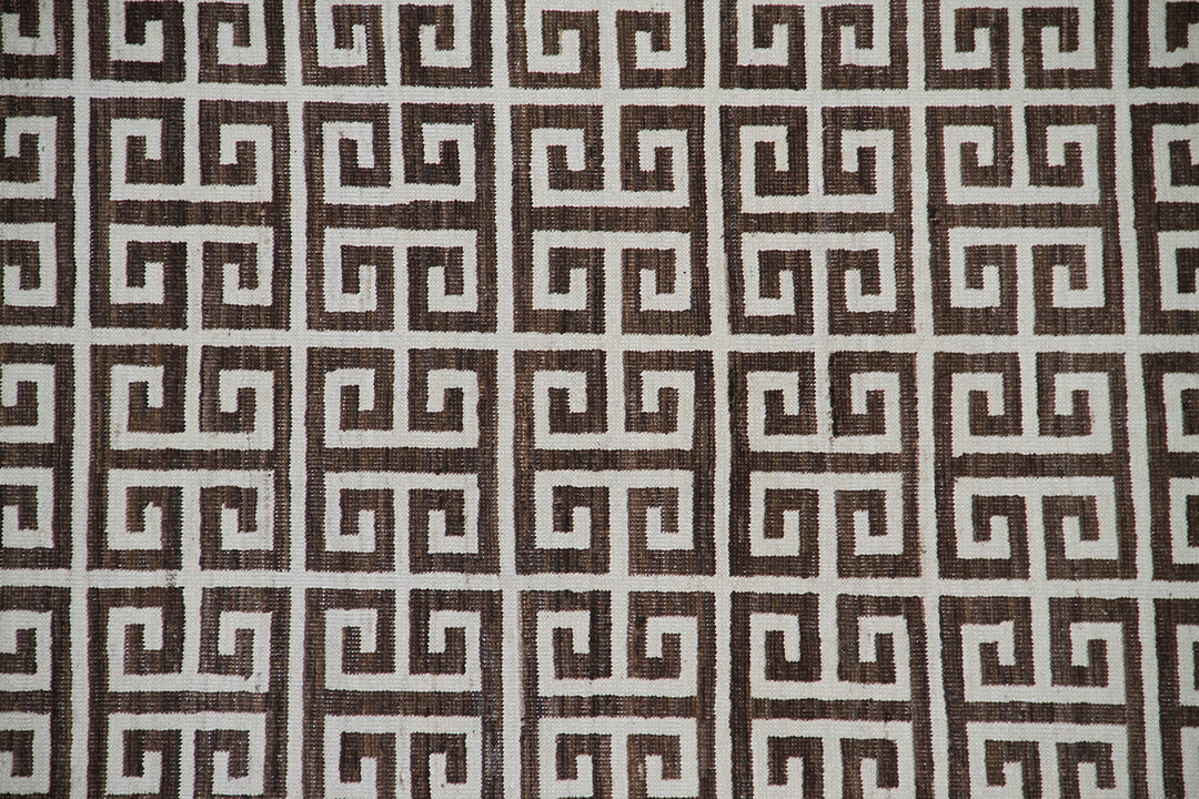 Close-up of 6'x9' Ariana Modern rug showing ivory white geometric lines on a dark brown background.