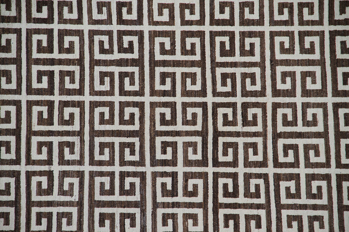 Close-up of 6'x9' Ariana Modern rug showing ivory white geometric lines on a dark brown background.