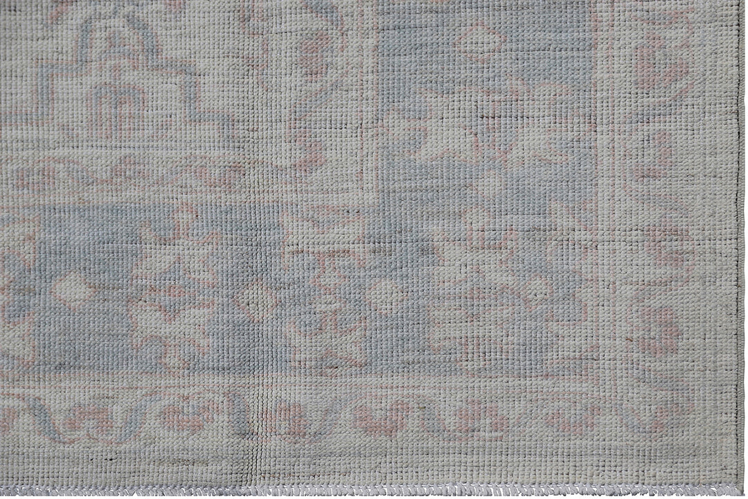 Authentic Ariana Transitional Collection 5x7 wool area rug featuring an ivory and cream geometric pattern with blue accents, ethically hand-knotted in Afghanistan.