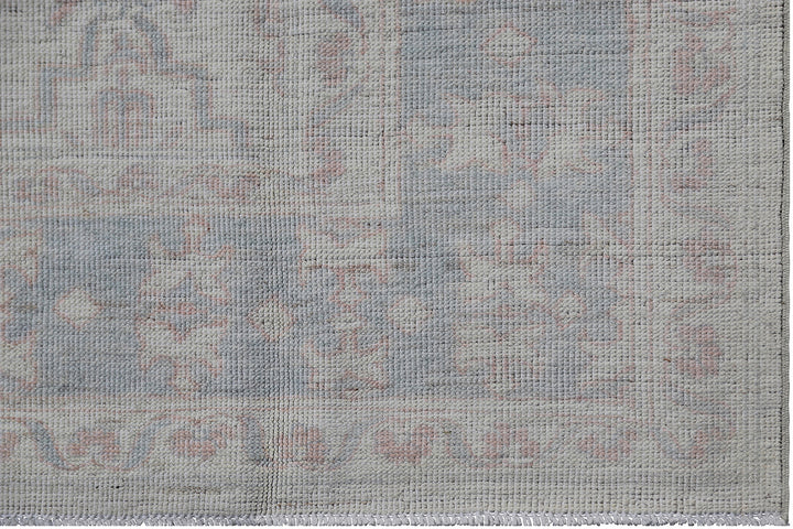 Authentic Ariana Transitional Collection 5x7 wool area rug featuring an ivory and cream geometric pattern with blue accents, ethically hand-knotted in Afghanistan.