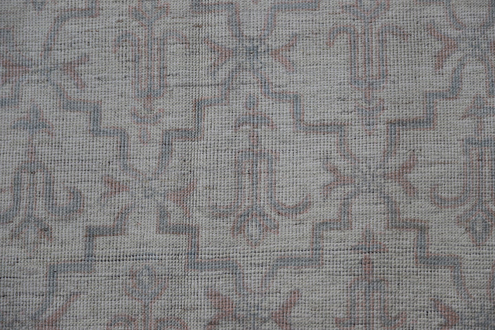 Authentic Ariana Transitional Collection 5x7 wool area rug featuring an ivory and cream geometric pattern with blue accents, ethically hand-knotted in Afghanistan.