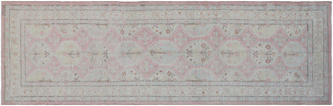Authentic hand-knotted Afghan runner rug from the Ariana Hazara Collection, featuring geometric Caucasian motifs in pink organic wool.