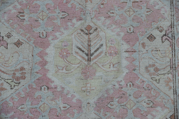 Authentic hand-knotted Afghan runner rug from the Ariana Hazara Collection, featuring geometric Caucasian motifs in pink organic wool.
