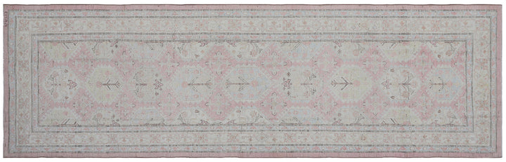 Authentic hand-knotted Afghan runner rug from the Ariana Hazara Collection, featuring geometric Caucasian motifs in pink, ivory, and blue organic wool.