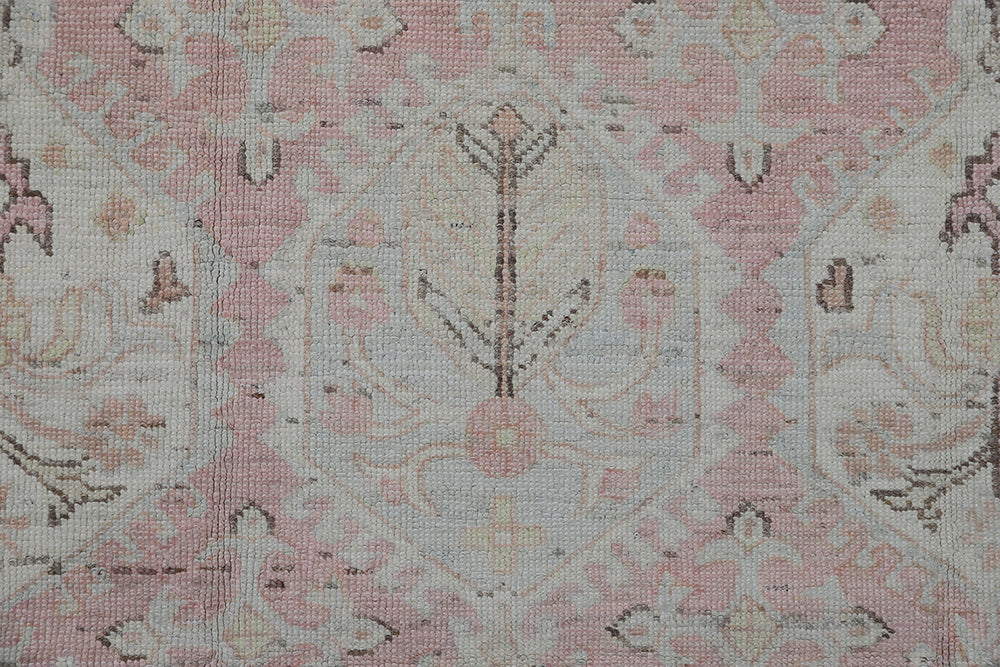 Authentic hand-knotted Afghan runner rug from the Ariana Hazara Collection, featuring geometric Caucasian motifs in pink, ivory, and blue organic wool.