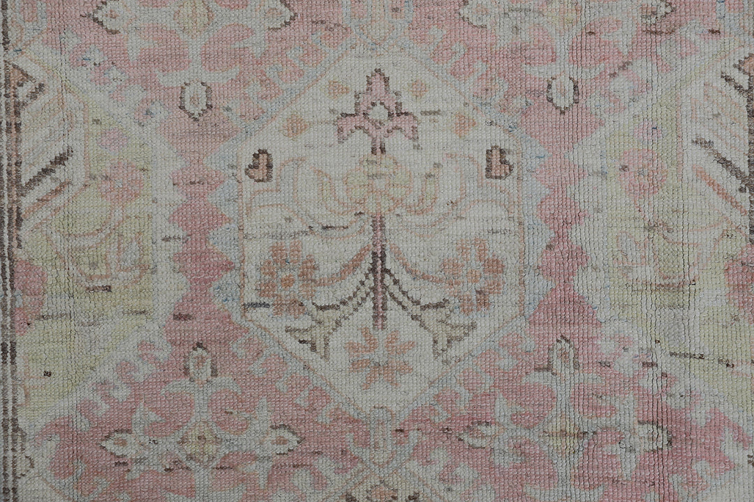 Authentic hand-knotted Afghan runner rug from the Ariana Hazara Collection, featuring geometric Caucasian motifs in pink, ivory, and blue organic wool.