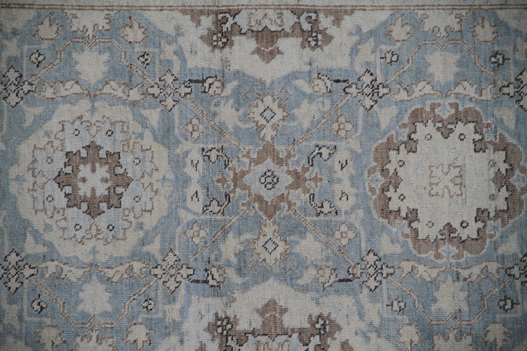 Authentic fine hand-knotted Afghan runner rug from the Ariana Traditional Collection, featuring the Agra 505 Blue design in low-pile blue, ivory, and brown organic wool.