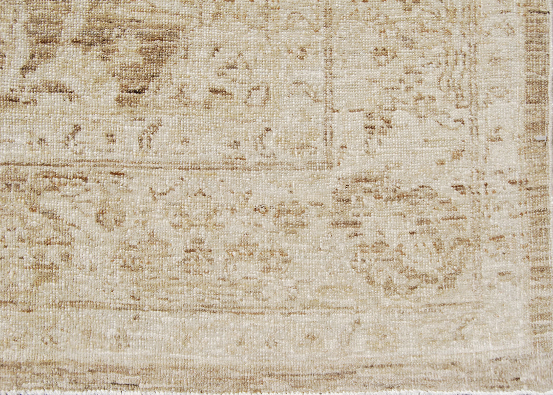 Authentic hand-knotted Afghan area rug from Ariana Rugs, featuring a muted Persian floral design in soft pale gold, light brown, and cream wool woven by Hazara women artisans.