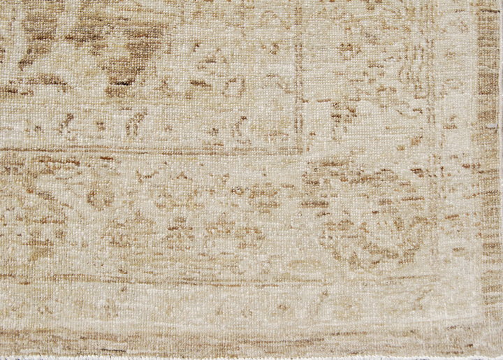 Authentic hand-knotted Afghan area rug from Ariana Rugs, featuring a muted Persian floral design in soft pale gold, light brown, and cream wool woven by Hazara women artisans.